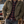 Load image into Gallery viewer, A man wearing an olive green fleece-lined jacket over a red and black plaid flannel shirt and blue jeans stands on a wooden dock by a lake, with a golden retriever lying nearby.

